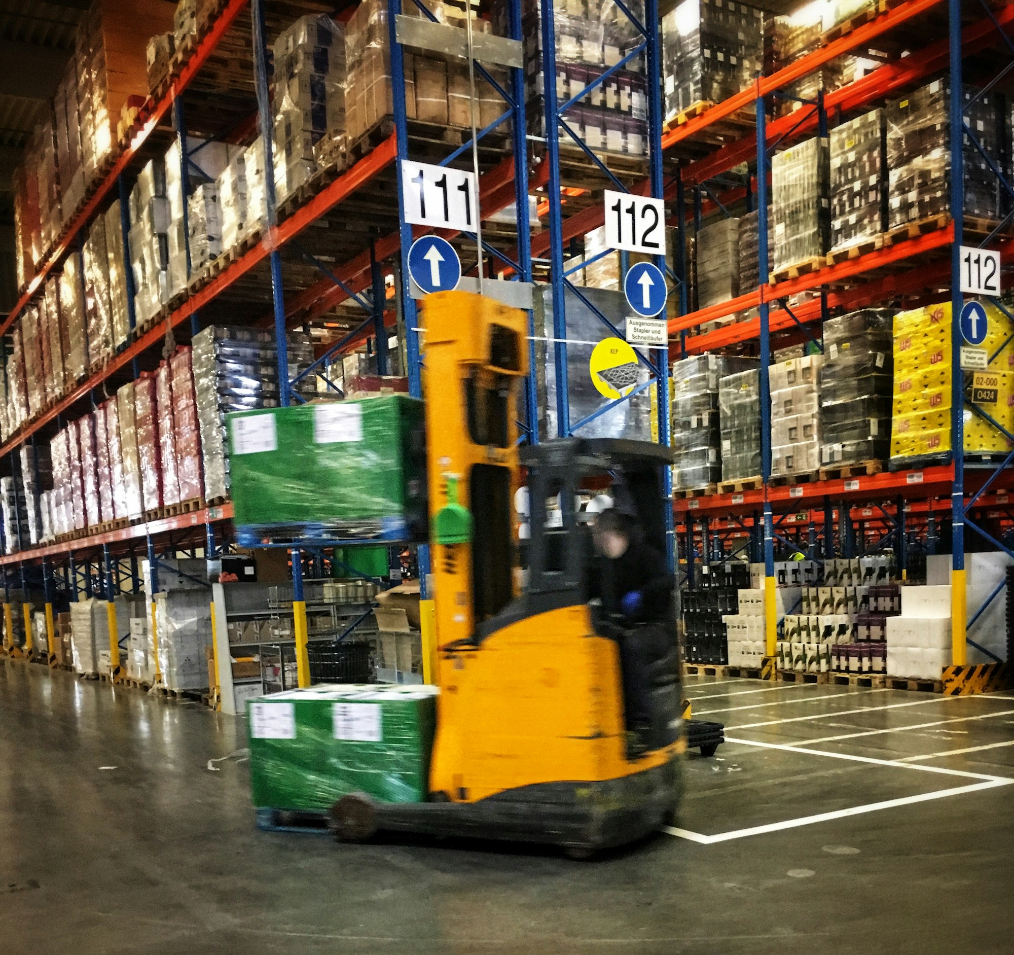 Forklift moving stock in a parts warehouse